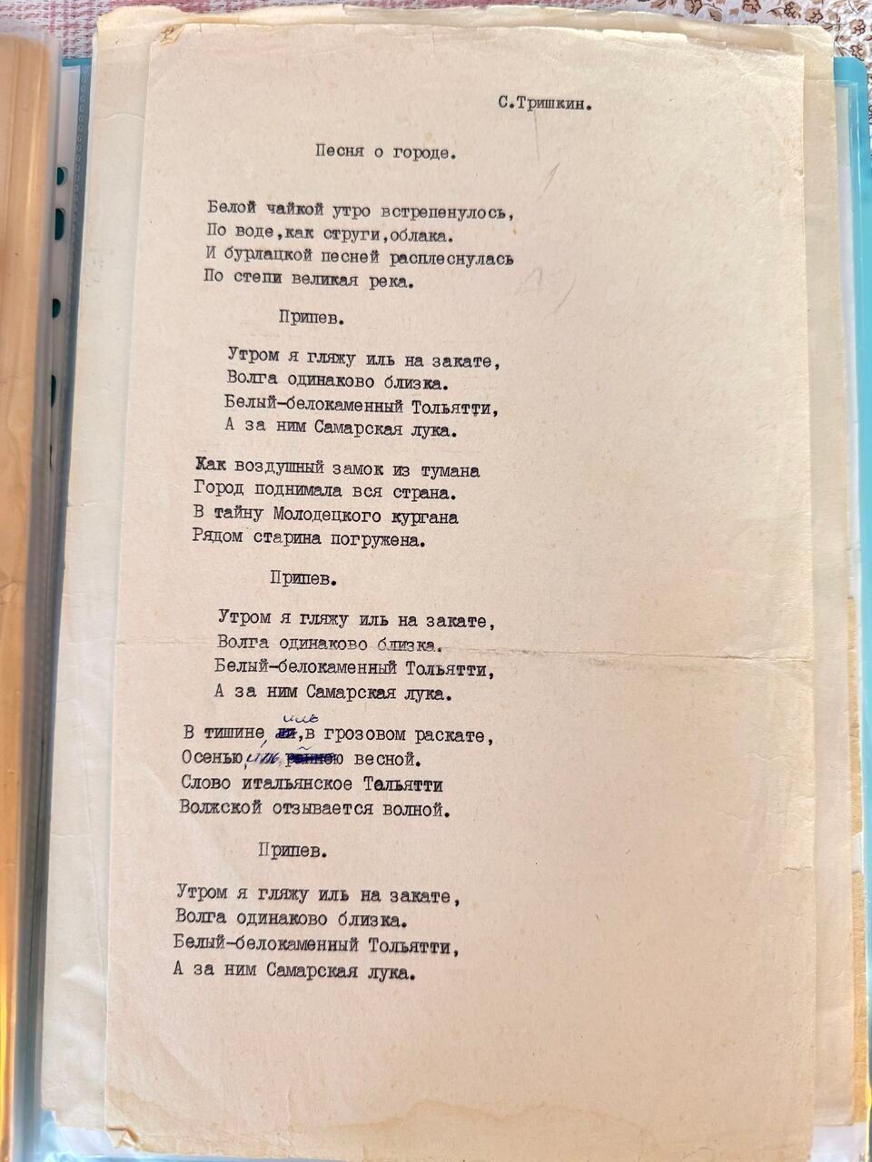 Машинописный лист с подписью «С. Тришкин» вверху: «Песня о городе» с повторяющимся припевом о Волге и Тольятти; в одной из строк — правка синими чернилами.