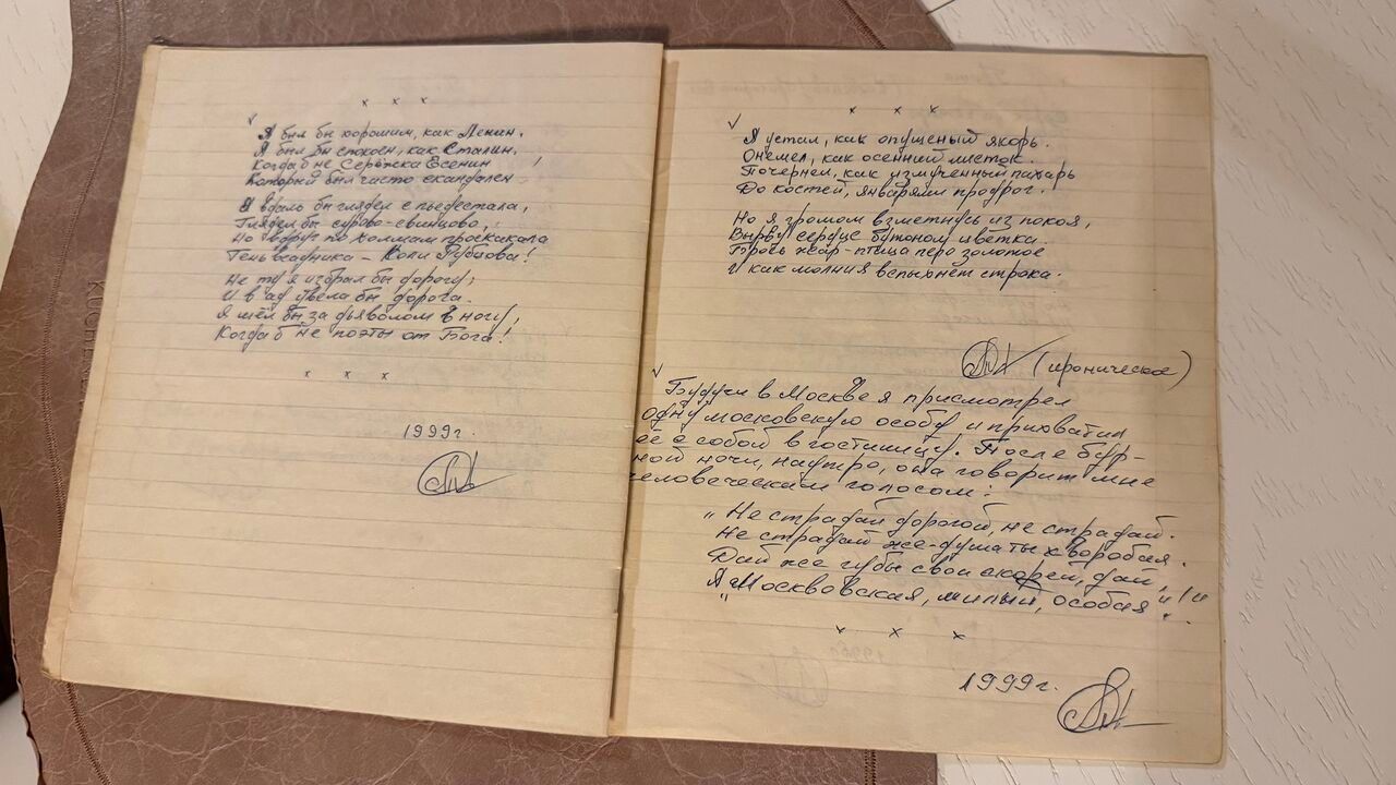 Разворот тетради в линейку с рукописными стихами синими чернилами; на обеих страницах — подпись и пометка «1999 г.»